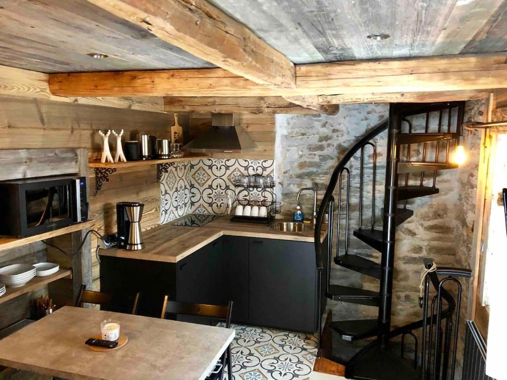 a kitchen with a table and a staircase in a room at le mazot d'urbain in Tignes