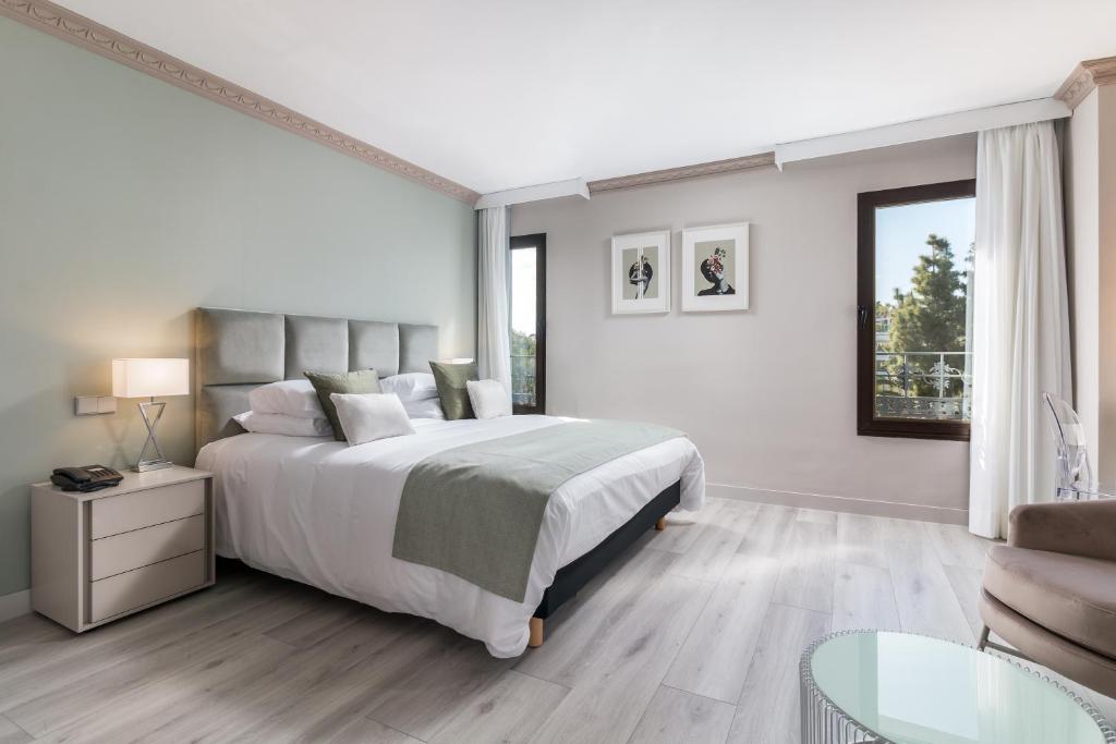een witte slaapkamer met een groot bed en een bank bij Boutique Hotel B51 in Marbella