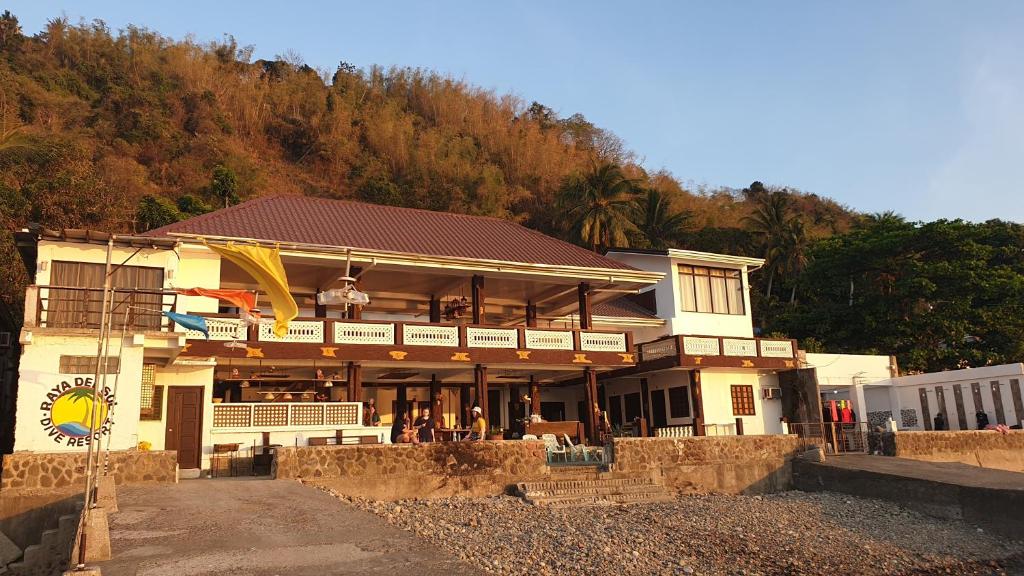 ein Gebäude mit einem Restaurant an der Seite eines Hügels in der Unterkunft Raya Del Sol Dive Resort in Mabini