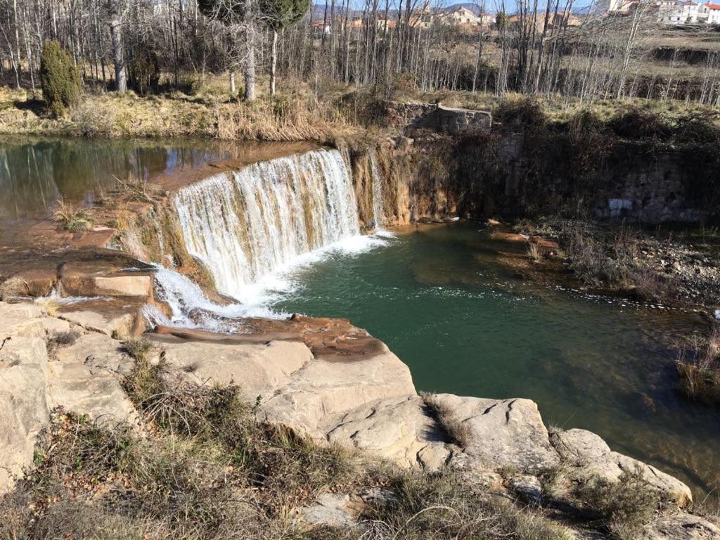 a waterfall in front of a pool of water at Monolocal rural con encanto in Valbona