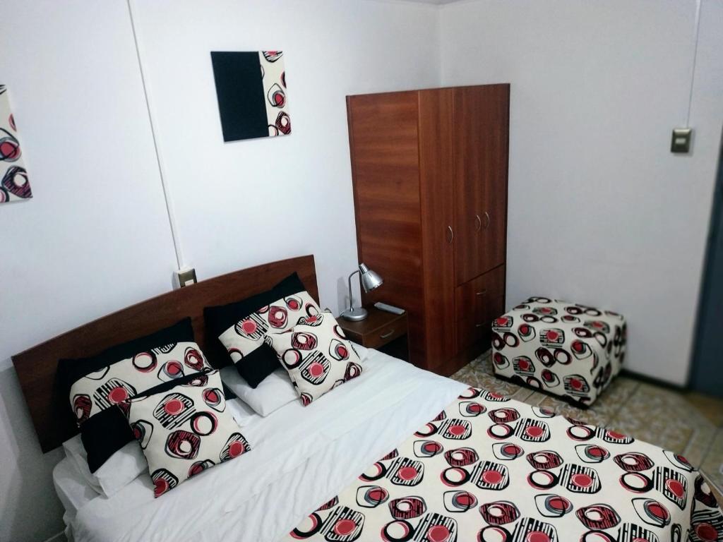 a bedroom with a bed and a suitcase in it at Playa Blanca B&B Antofagasta in Antofagasta