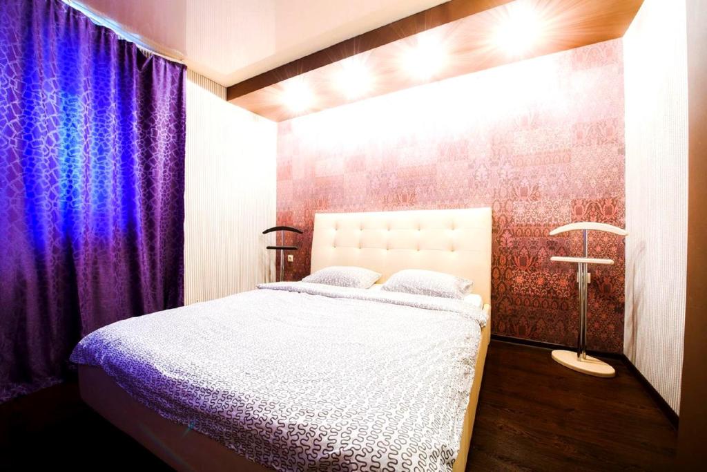 ウファにあるИбрагимова бульвар,46 Двухкомнатные апартаментыのベッドルーム1室(紫色のカーテン付きのベッド1台付)