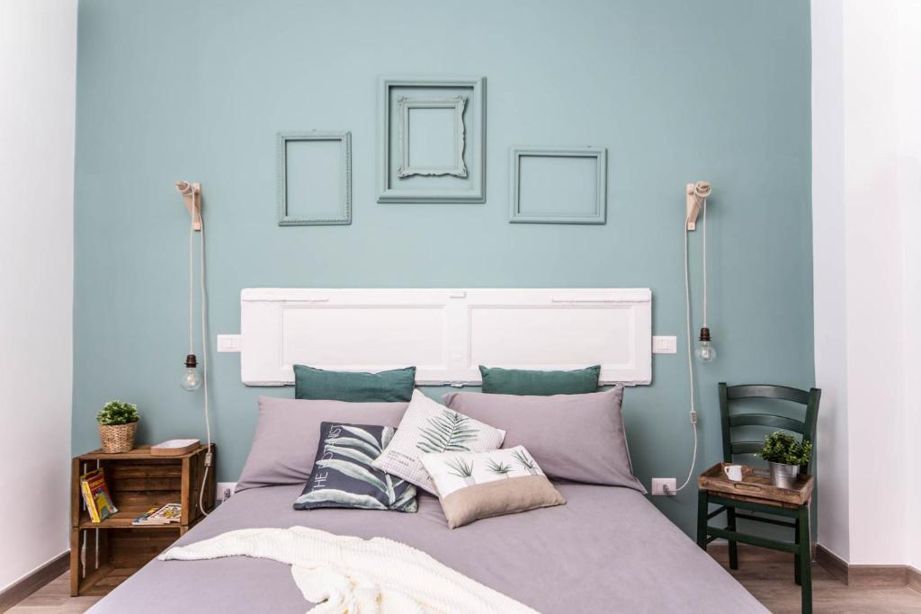 Schlafzimmer mit blauen Wänden und einem Bett mit Kissen in der Unterkunft ilbricco in Neapel