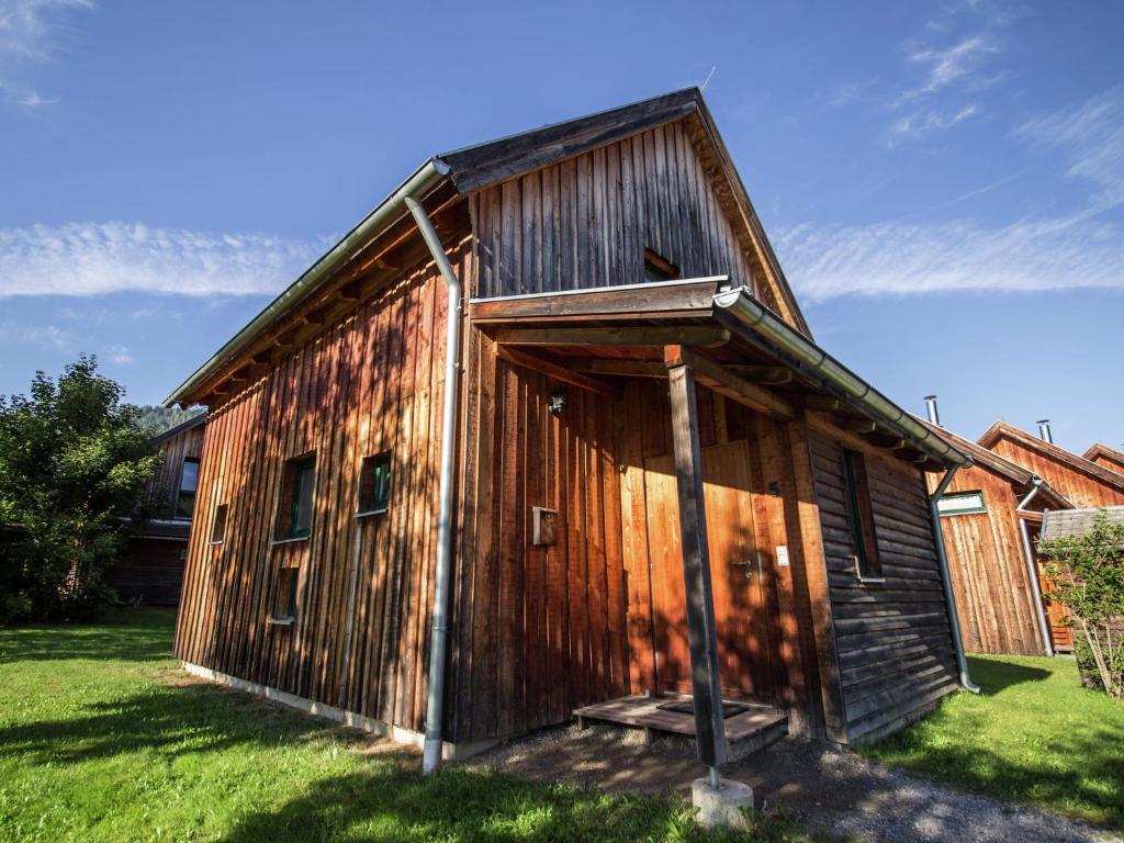 an old wooden building in a field of grass at Modern Holiday Home in Sankt Georgen with Swimming Pool in Sankt Lorenzen ob Murau