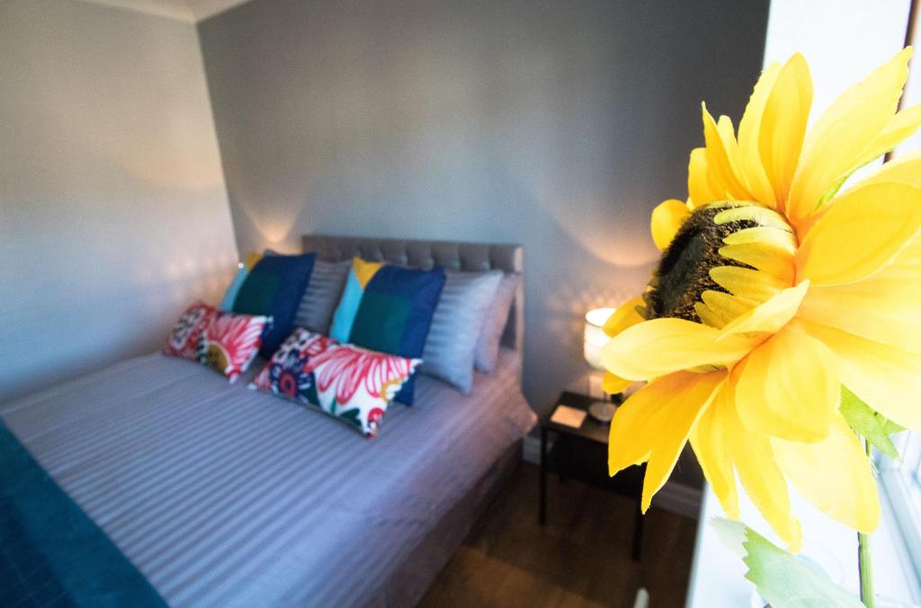 a room with a bed and a yellow sunflower at Ideal Lodgings in Bury - Fairfield in Bury