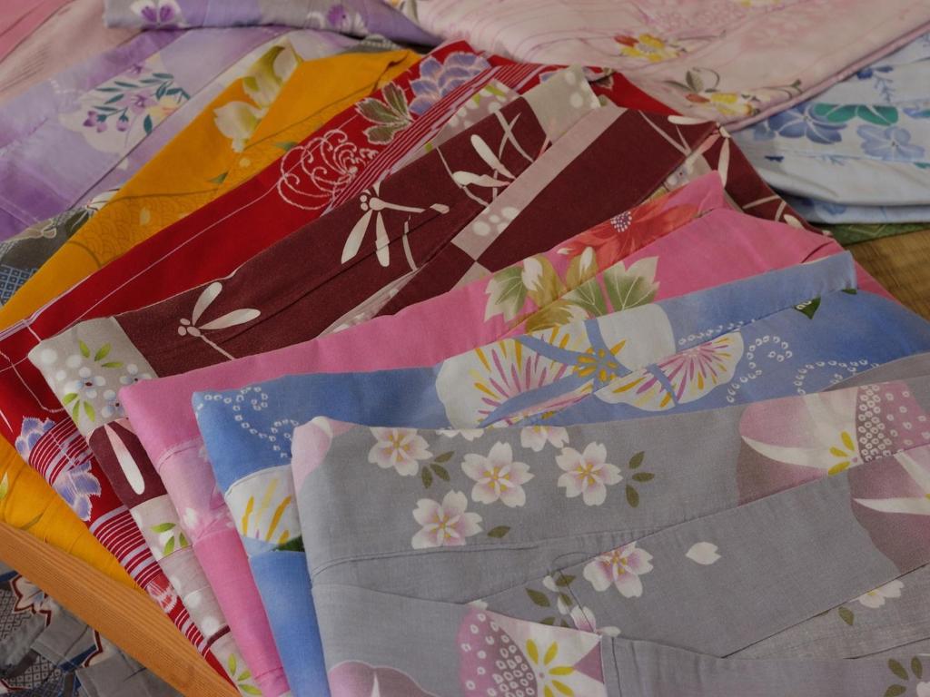 a pile of colorful quilts on a table at Inatori Tokai Hotel Yuen in Higashiizu
