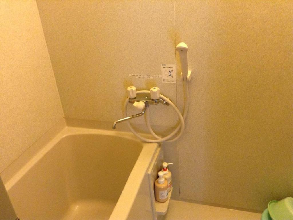 a bathroom with a bath tub and a shower at Inatori Tokai Hotel Yuen in Higashiizu