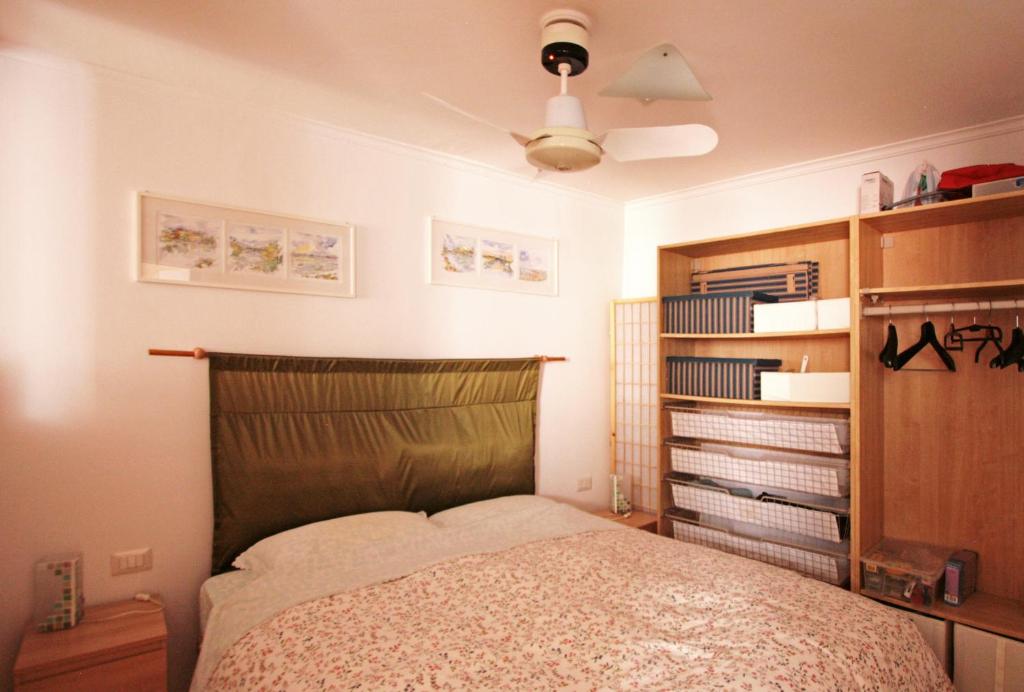 Roma center Fori Imperiali Raffy's charming Suite في روما: غرفة نوم بسرير ومروحة سقف