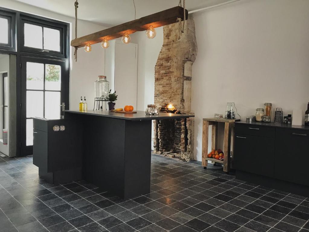 uma cozinha com um balcão preto num quarto em De Pastorie em Middelburg