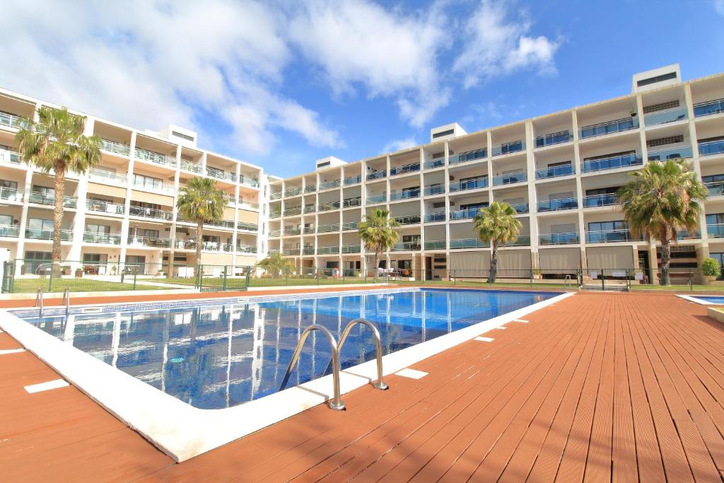 een groot appartementencomplex met een zwembad ervoor bij Tim House in Olhão