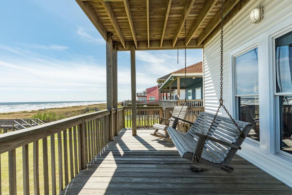 a porch with two benches and the beach at Sunrise in Paradise in Galveston