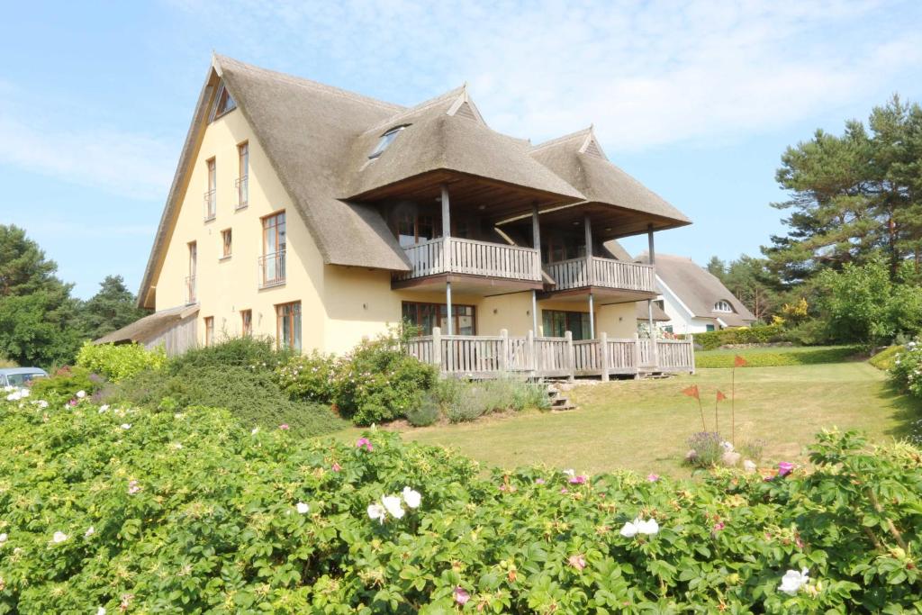 een groot huis met een gambrel dak bij Fewos Herrmann Achterwasserblick in Loddin