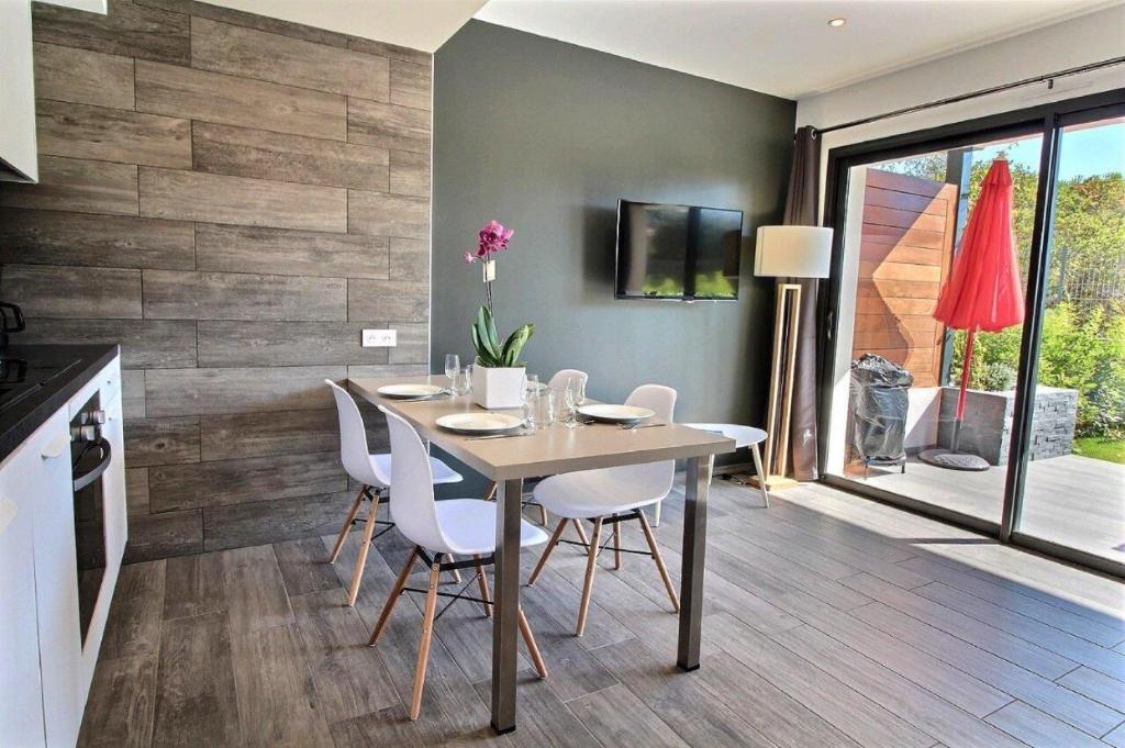 a dining room with a table and white chairs at Residence ACQUA LINDA Porticcio in Porticcio