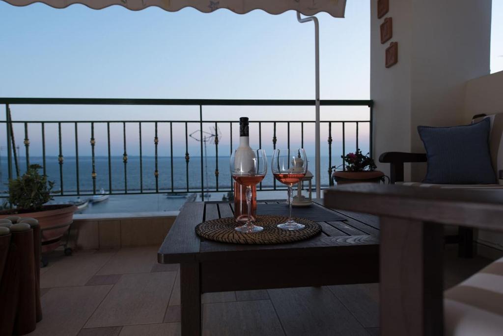 a table with two glasses and a bottle of wine at Apartment with marina view in Thessaloniki