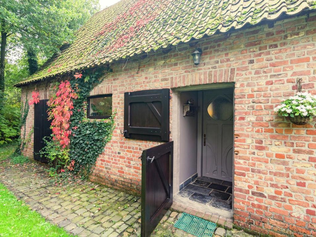 een stenen huis met een deur en een raam bij This accommodation is full of atmosphere and on a beautiful estate in Zedelgem