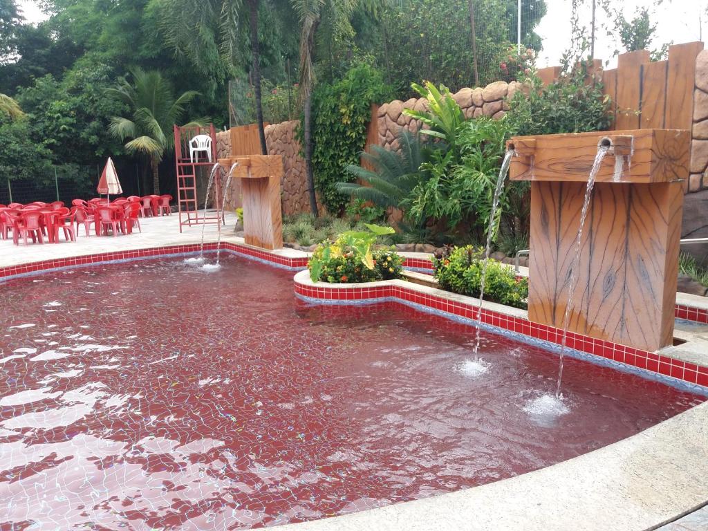 una piscina con una fuente de agua en un patio en Suíte Golden Dolphin Grand Hotel, en Caldas Novas