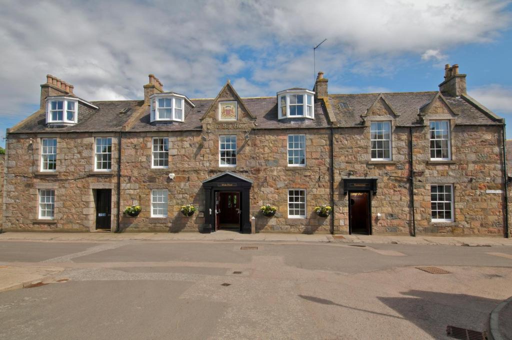 an old stone building with two doors and windows at Cove Bay Hotel in Aberdeen