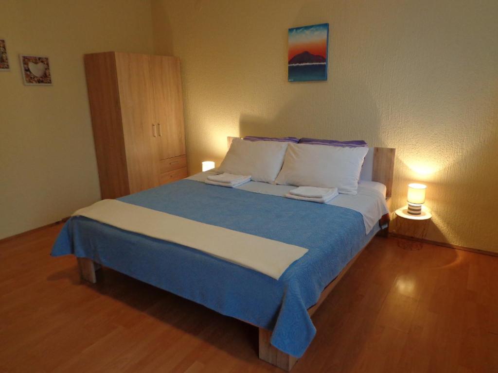 una camera da letto con un grande letto con lenzuola blu e bianche di Guesthouse Aotearoa Premantura a Premantura