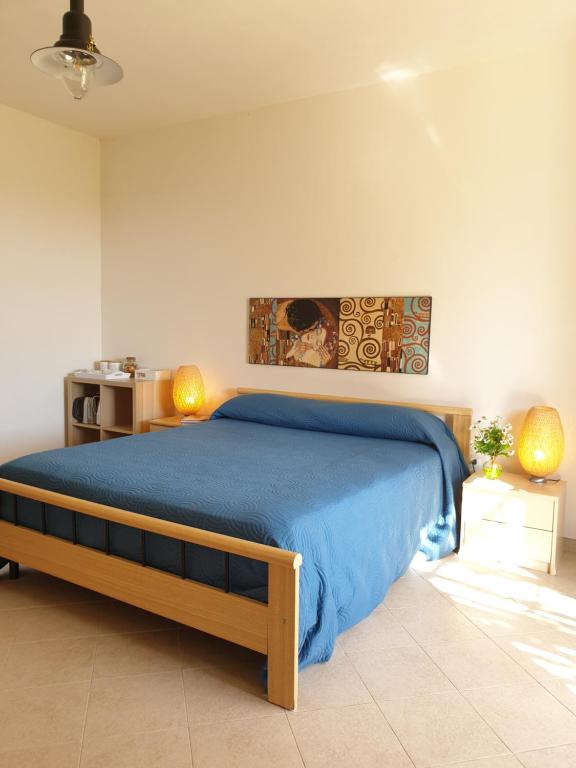 a bedroom with a bed with a blue blanket at Trenasse in Marsala