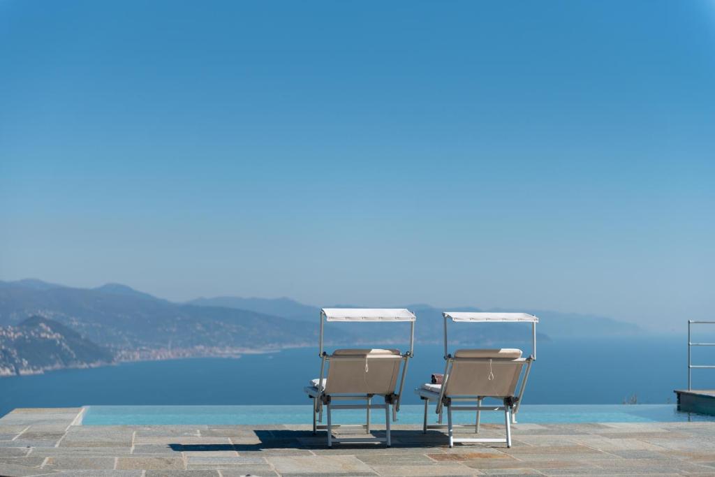 two chairs sitting on a patio overlooking the water at Il Leccio - Luxury Resort Portofino Monte in Santa Margherita Ligure
