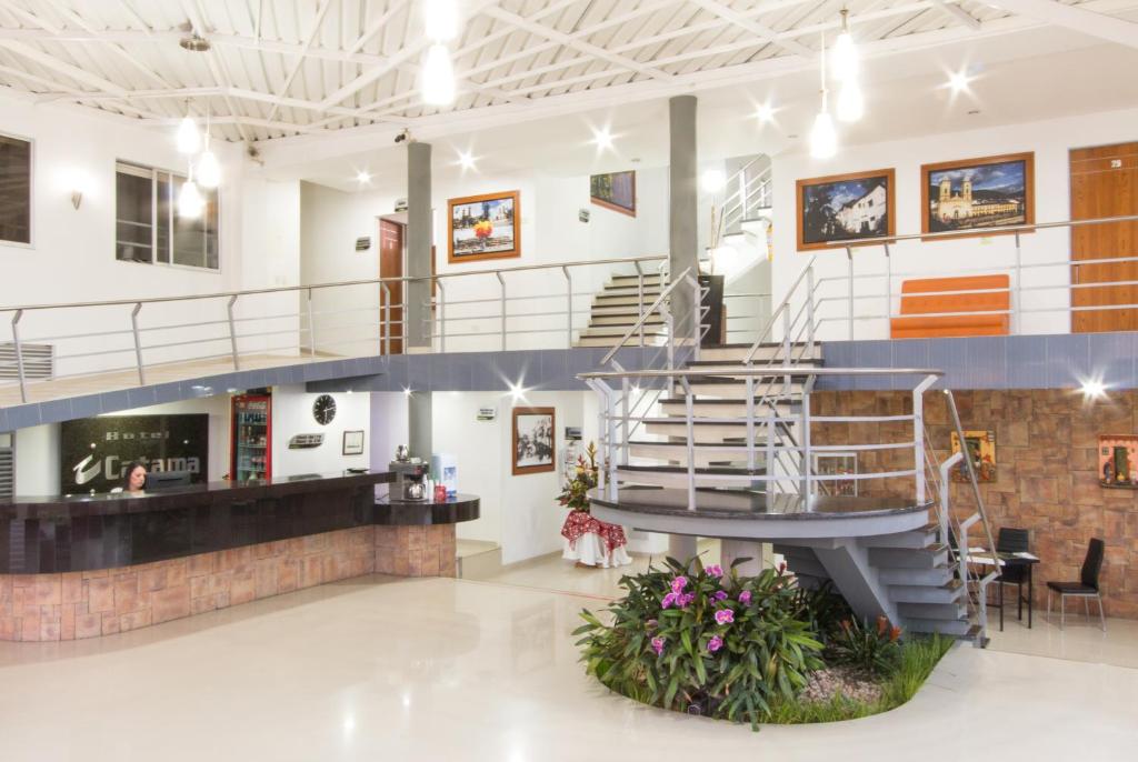 a lobby with a spiral staircase in a building at Hotel Catama Inn in Fusagasuga