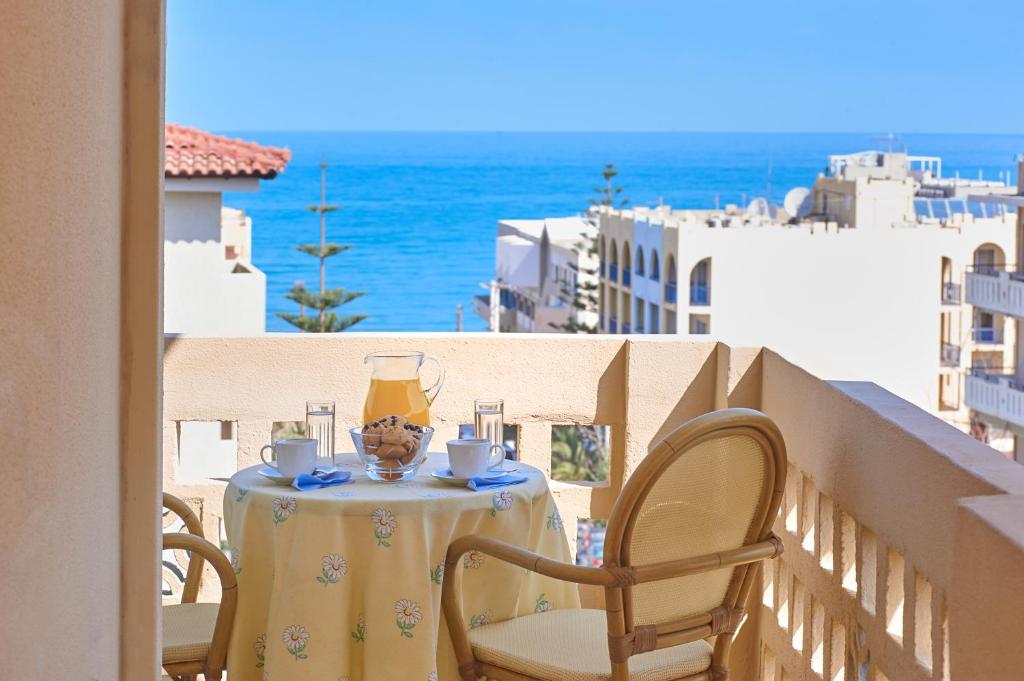 a table and chairs on a balcony with a view of the ocean at Amalia's Sea View Home in Rethymno Town