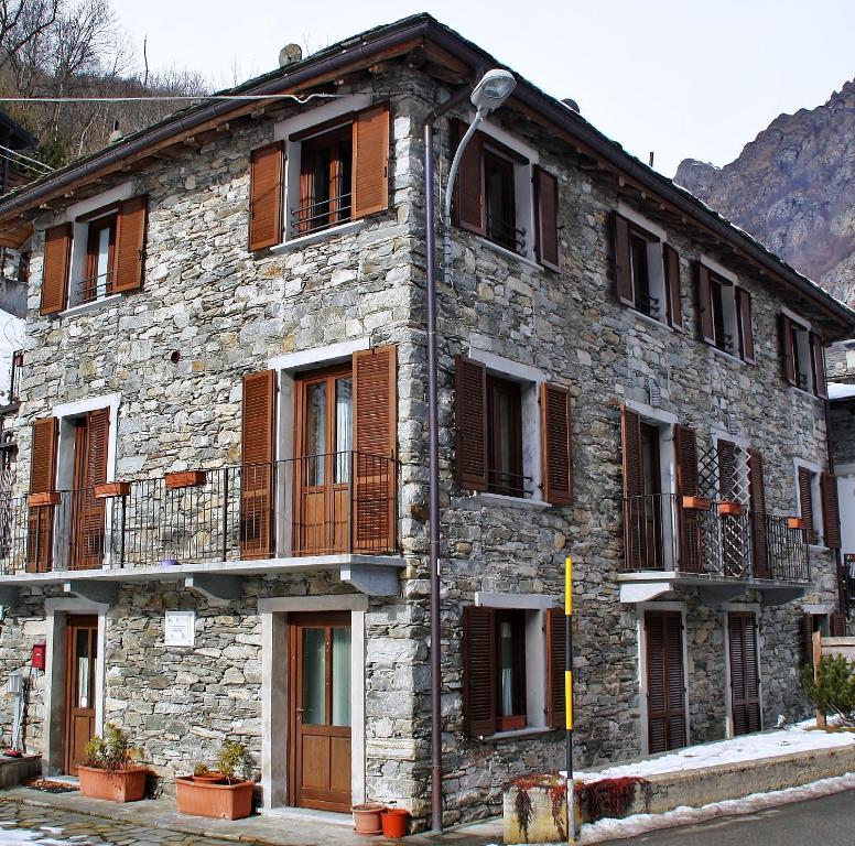 Edificio de piedra antiguo con ventanas y balcón en Casa Rimasco, en Rimasco