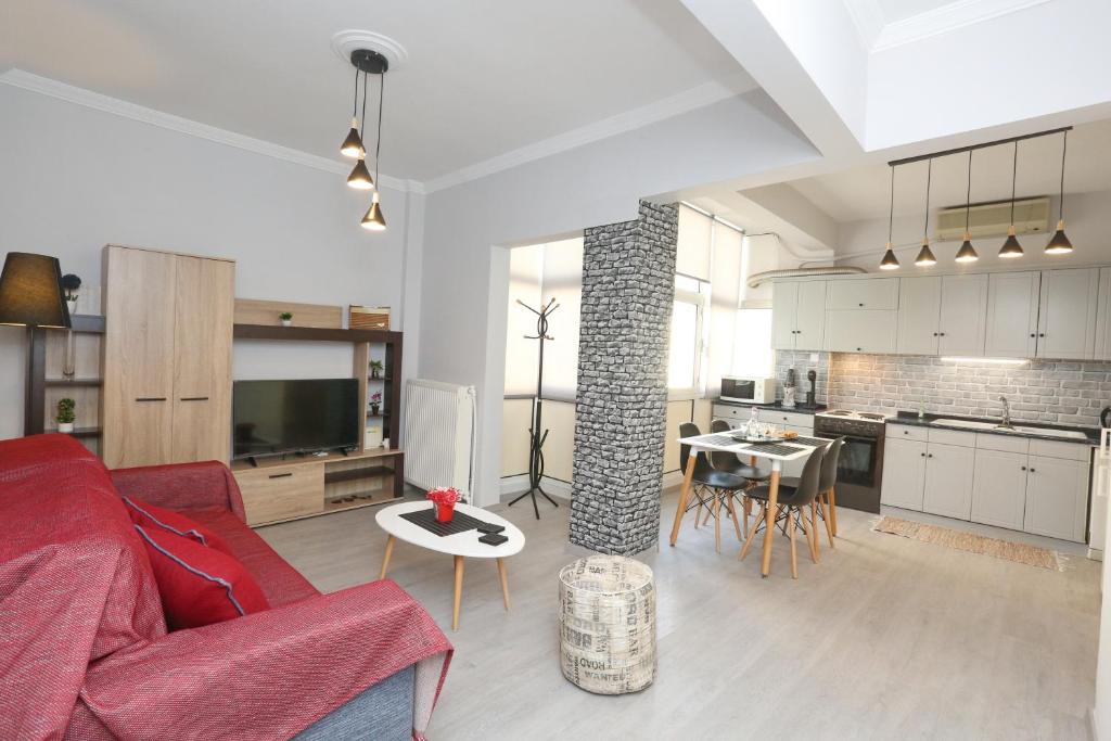 un soggiorno con divano rosso e una cucina di Oli's Luxury Apartment a Salonicco