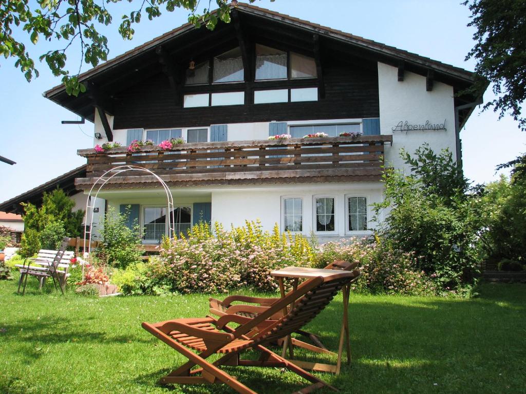 ein Haus mit einem Tisch und Stühlen im Hof in der Unterkunft Gästehaus Alpenland in Halblech