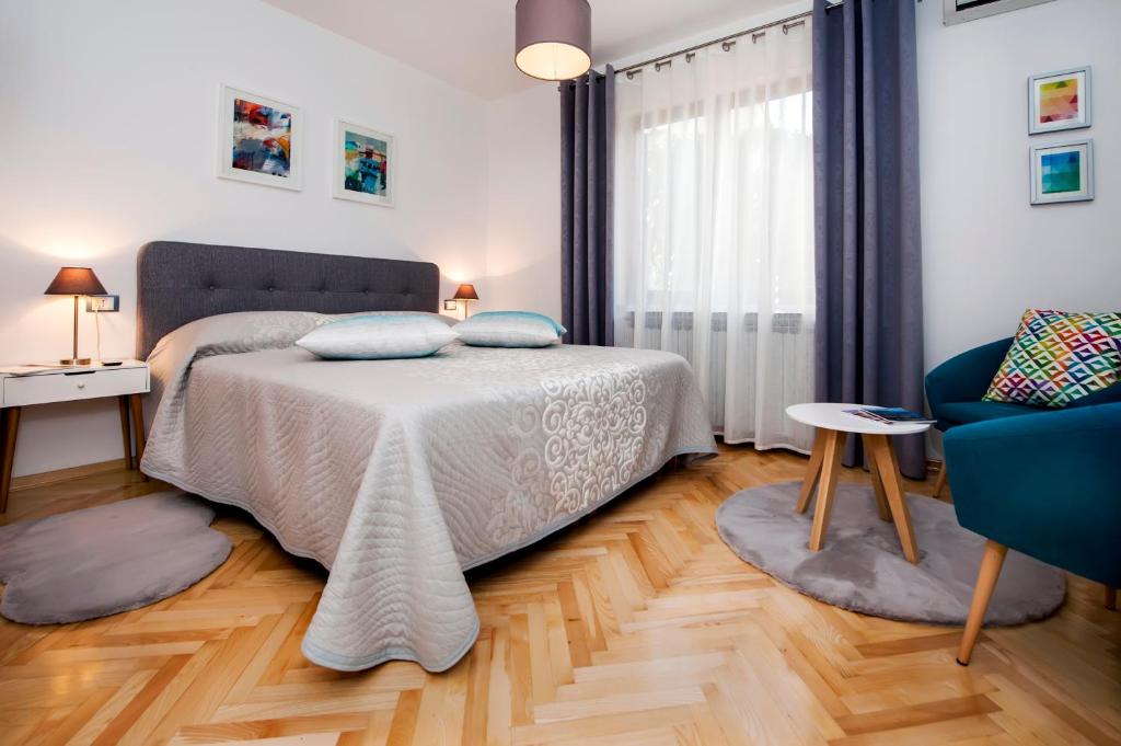 een slaapkamer met een bed en een blauwe stoel bij Studio Noah in Rovinj