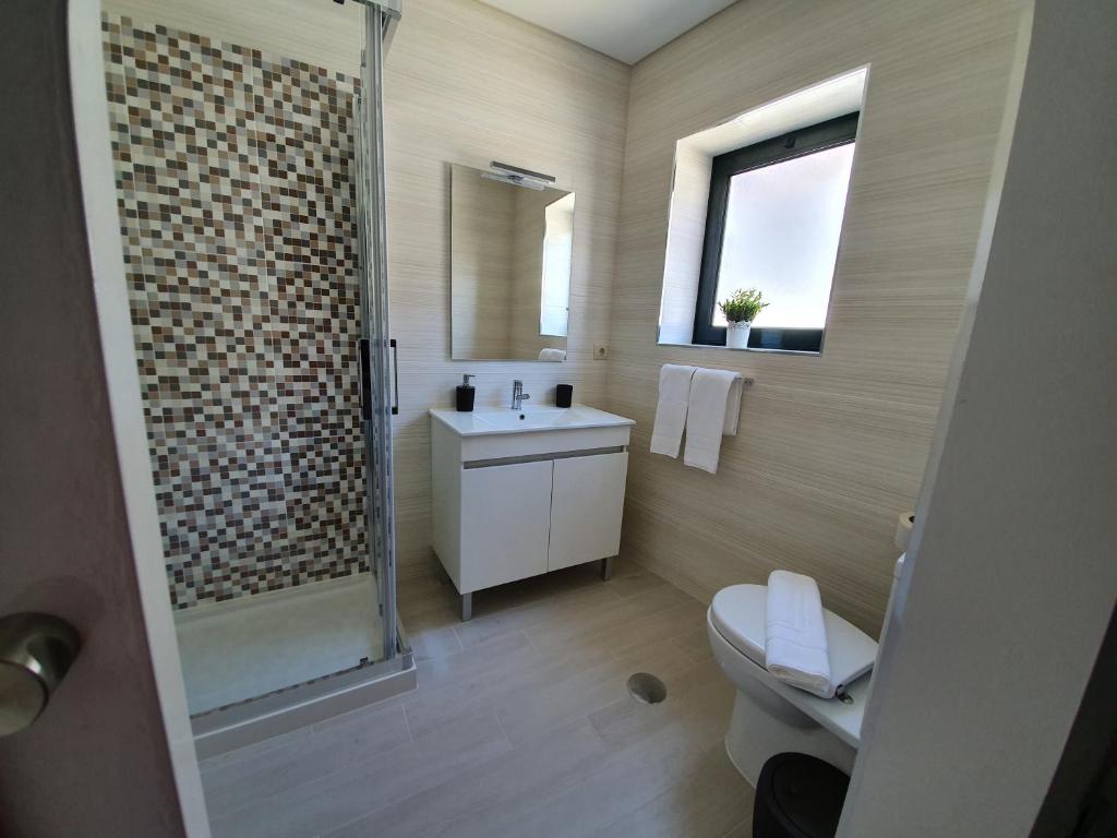 a bathroom with a shower and a toilet and a sink at Casa Dos Arcos in Aveiro