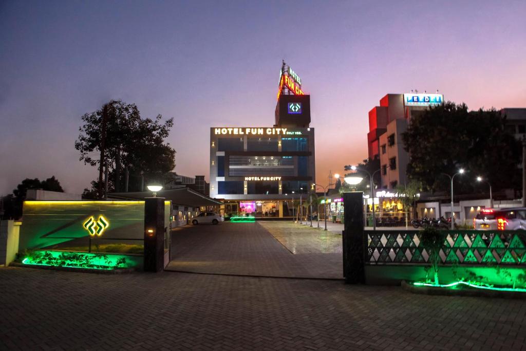 a large building with a clock tower at night at Hotel Fun City in Navsāri
