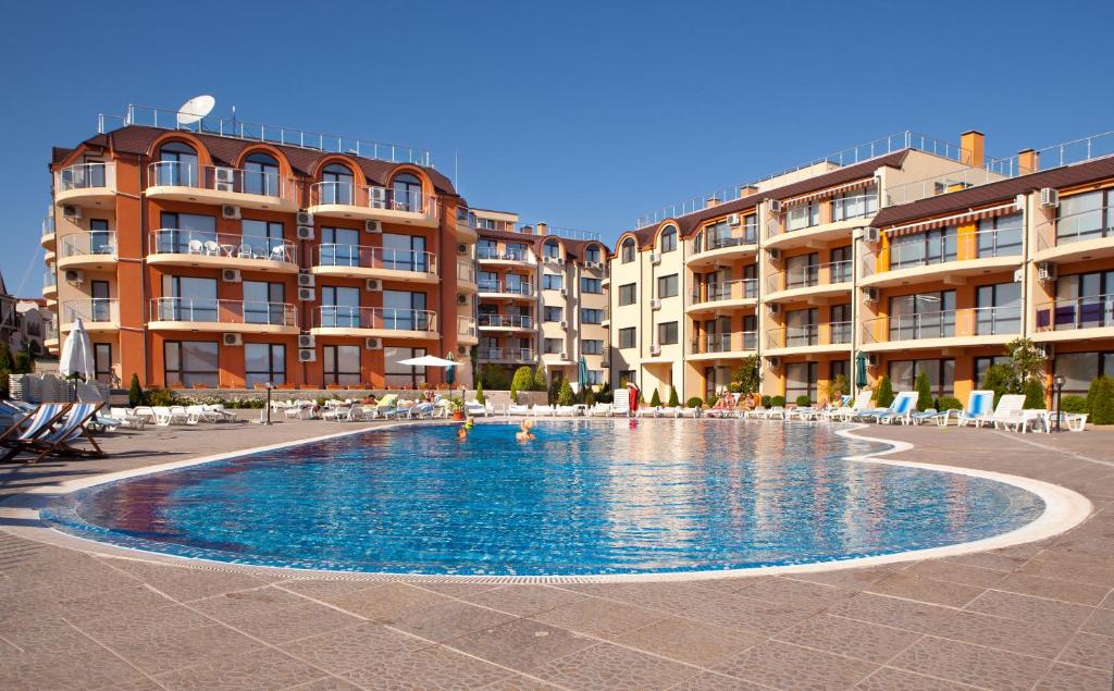 a swimming pool in front of some apartment buildings at Sun Sea Resort in Ravda