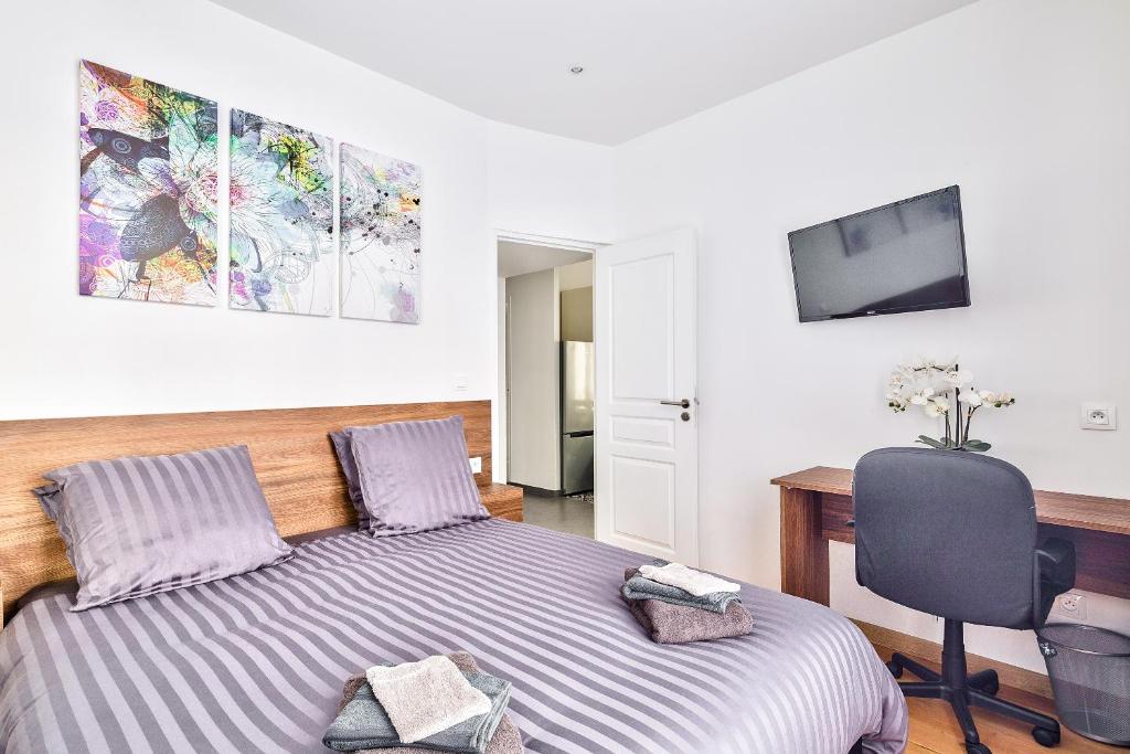 a bedroom with a bed and a desk and a chair at The Pearl Suite in Vitry-sur-Seine