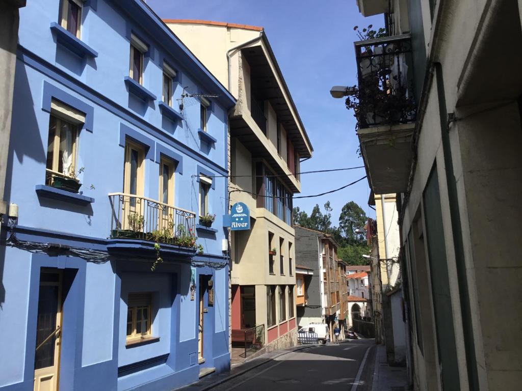 an alley with blue buildings on a city street at Pension Alver in Cudillero