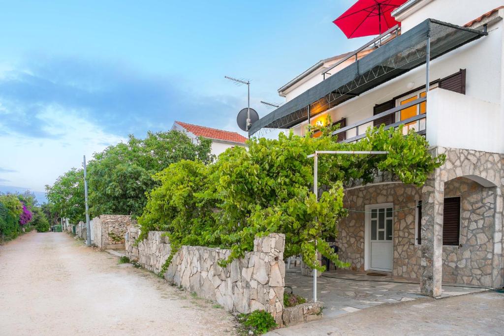 un edificio con una sombrilla roja junto a una calle en Silver Beach Apartments Vis en Vis