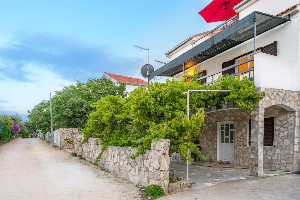 a building with a red umbrella next to a street at Silver Beach Apartments Vis in Vis
