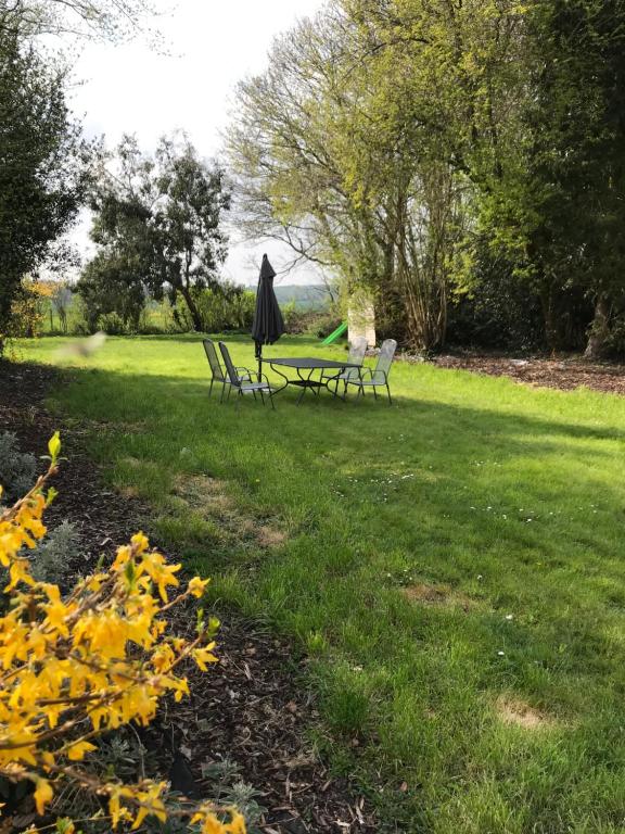 twee picknicktafels en een paraplu in een park bij Barnfield Bed and Breakfast in Downton