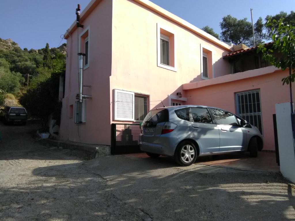 mały srebrny samochód zaparkowany przed domem w obiekcie Garden Of Olive Trees w mieście AsfendhilÃ©s