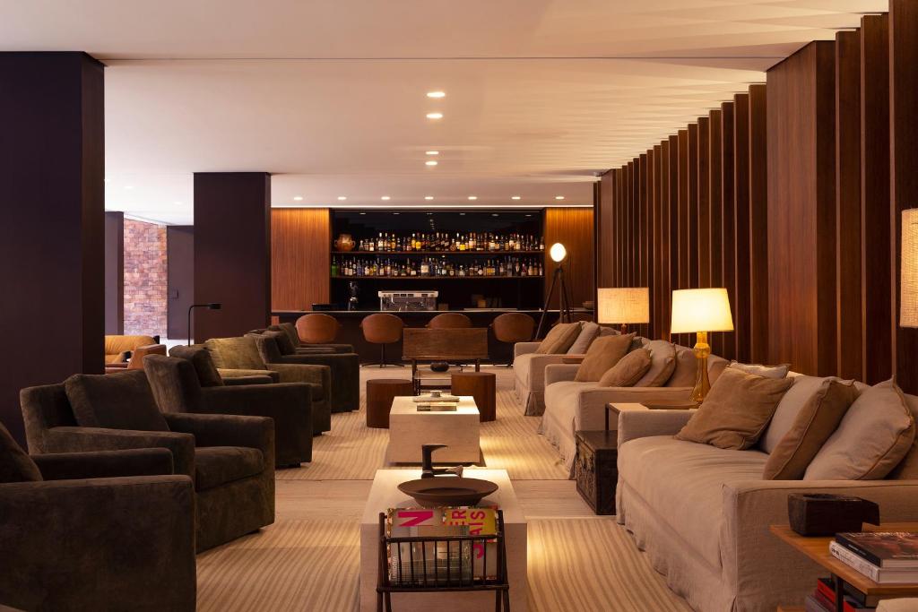 ein großes Wohnzimmer mit Sofas und einer Bar in der Unterkunft Hotel Fasano Belo Horizonte in Belo Horizonte