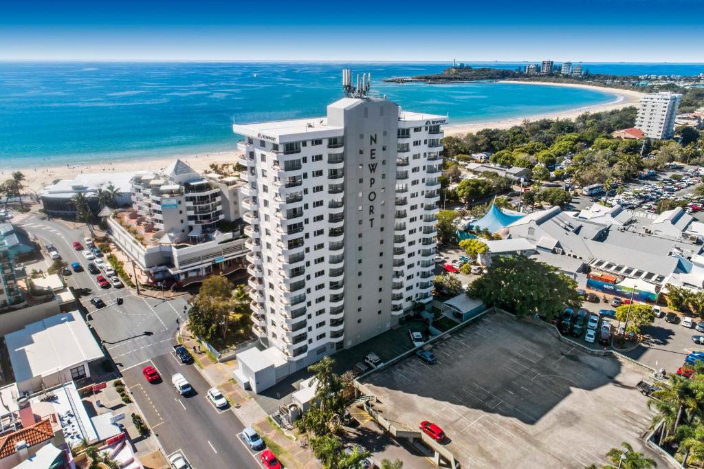 an aerial view of a tall white building next to the beach at Newport Mooloolaba Apartments in Mooloolaba