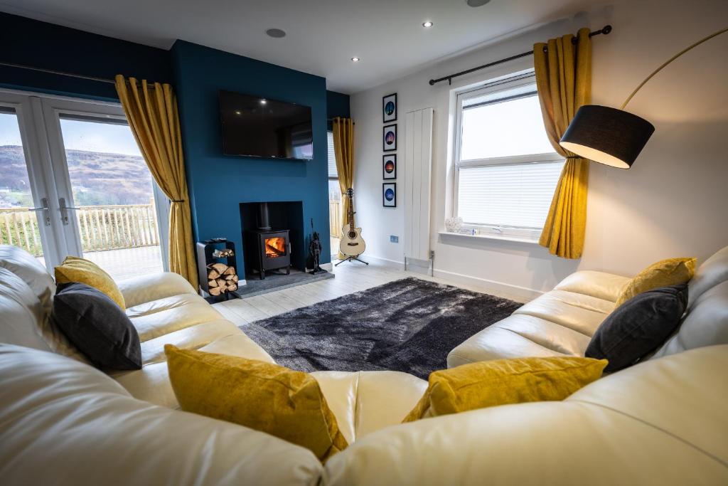 sala de estar con 2 sofás blancos y chimenea en Skye Bay en Portree