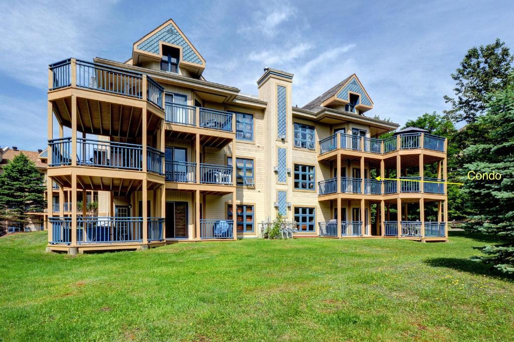 a large apartment building with a large yard at Condo Jardins du Village Mont-Tremblant in Mont-Tremblant