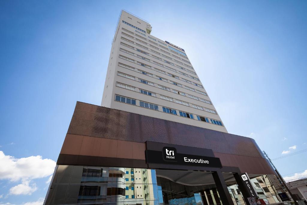 a tall building with a sign in front of it at Tri Hotel Executive Brusque in Brusque