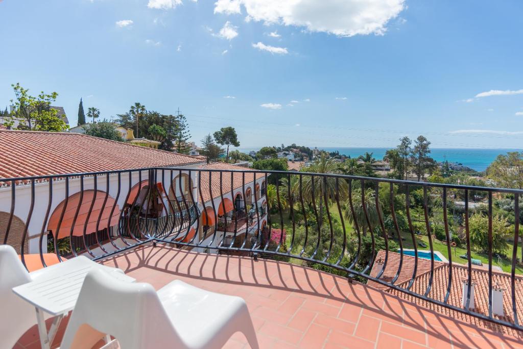 uma varanda com cadeiras brancas e vista para o oceano em LU&CIA JARDIN AL MAR em Málaga