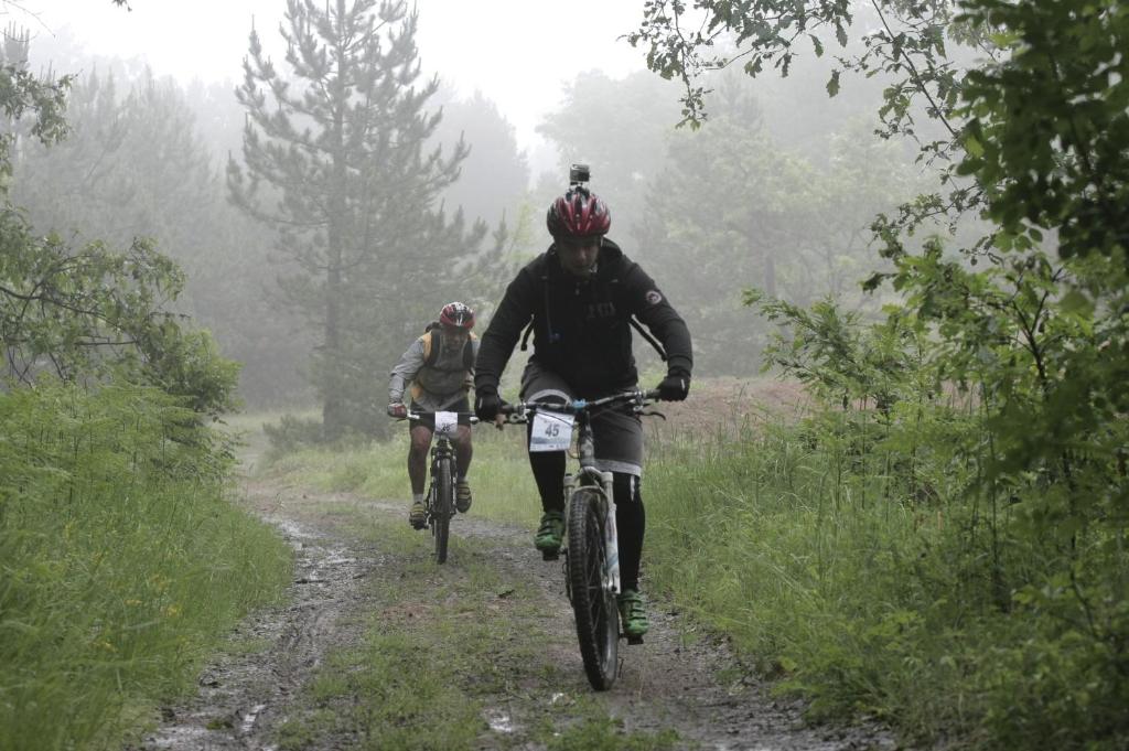 two people riding bikes down a dirt road at Planinarski dom "Tornik" Zlatibor in Ribnica