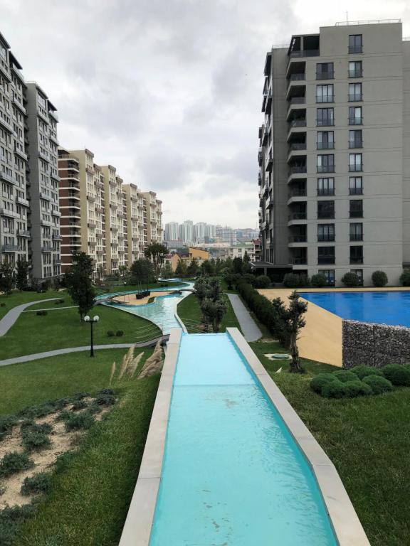 vistas a una piscina en un parque con edificios altos en Milpark Apartment, en Estambul