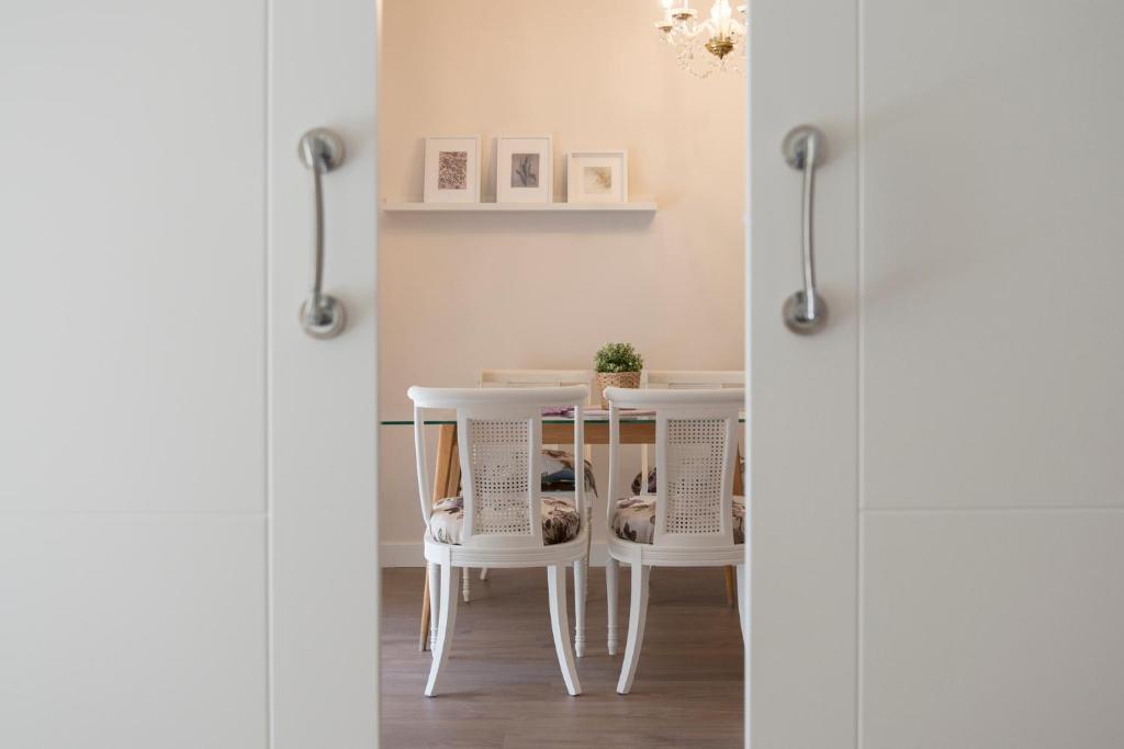 a dining room table with white chairs and a table at VUT Carreteria9 in Cuenca