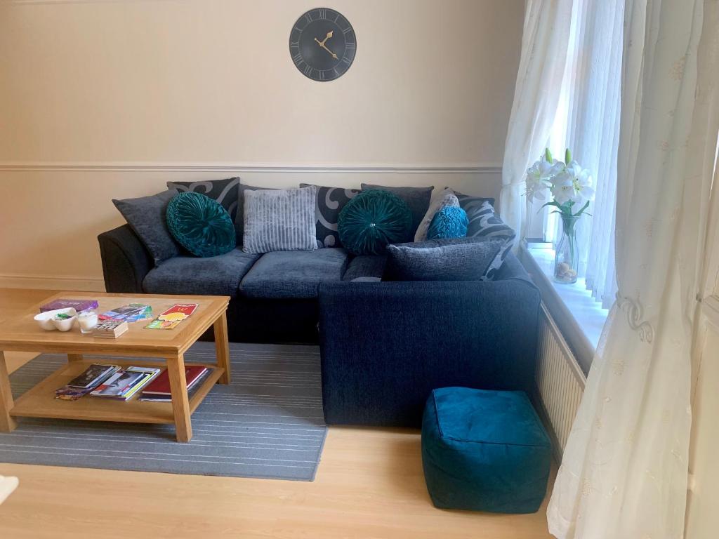 een woonkamer met een blauwe bank en een tafel bij Be My Guest Liverpool - Ground Floor Apartment with Parking in Liverpool