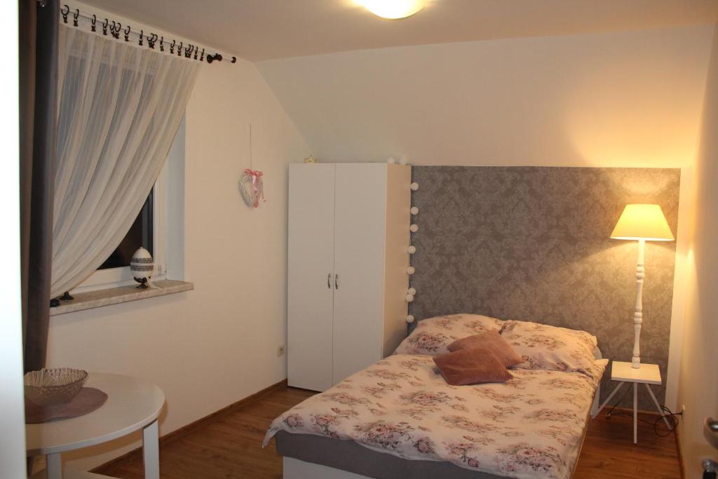 Un dormitorio con una cama con un osito de peluche. en Domek "Madzia", en Brenna